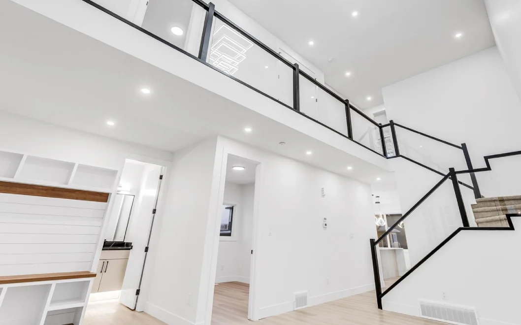 Double-height great room with open-to-above loft and black railing