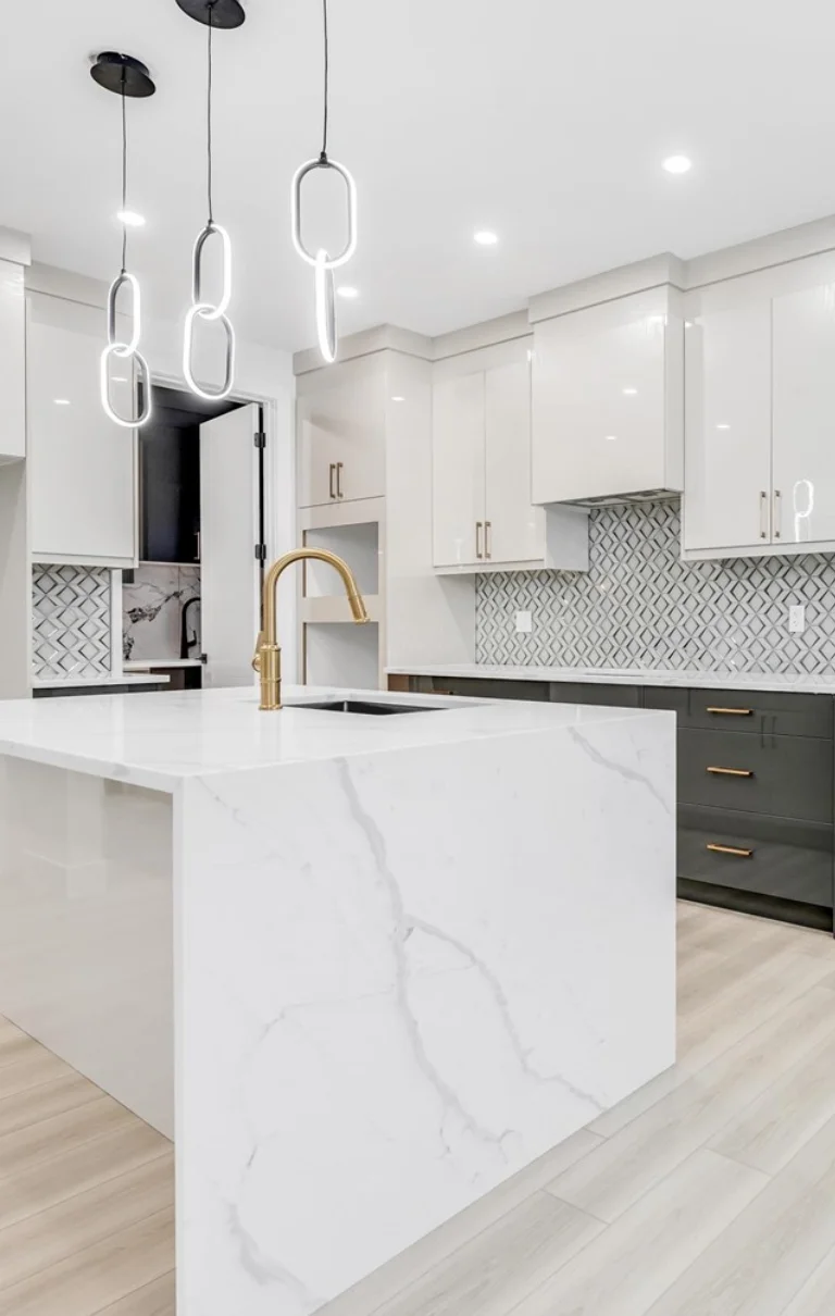 Waterfall quartz island with gold faucet and ring pendant lighting