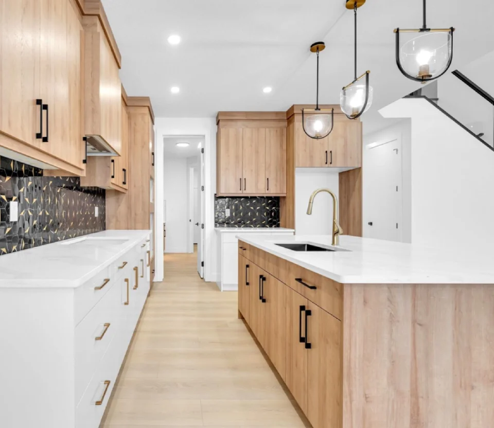 Custom home kitchen with white oak cabinetry and designer lighting